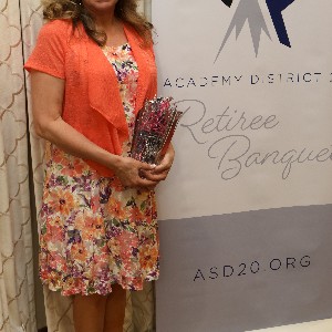 Yvonne Weyand smiles a for picture with her vase at the 2023 Retiree Banquet